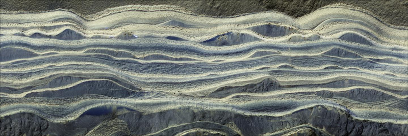 This composite image shows alternating layers of ice and sand in an area where they’re exposed on the surface of Mars. The water ice appears as light-colored, while the sand is darker blue.
